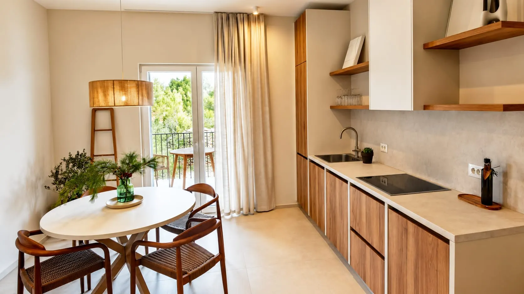 Kitchen and dining corner of a finished apartment: oak units, a round table and a balcony door to the pines.